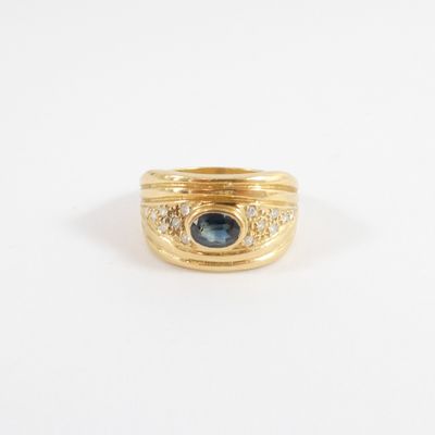an image of a gold ring with a blue sapphire and diamonds
