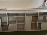 a white bookcase that is sitting on a green carpet