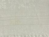 a close up of a white blanket with fringes on it