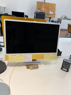 a computer monitor sitting on a desk in an office