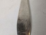 a silver spoon with a monogram on it sitting on a table