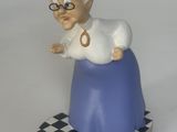 une figurine représentant une vieille femme assise sur un damier