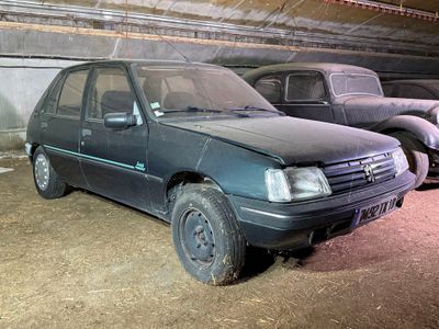 deux vieilles voitures garées l'une à côté de l'autre dans un garage