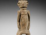 une statue en bois d'un homme avec un chapeau sur la tête