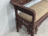 a wooden bench with a cushion on it in a room