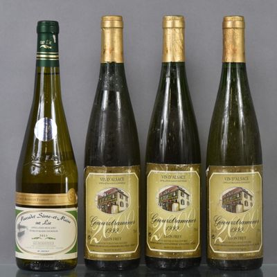 four bottles of wine are lined up on a table