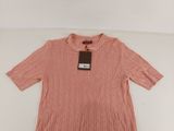 a pink sweater on a white surface