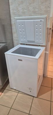 a small white chest freezer in the corner of a kitchen