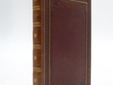 an old book sitting on top of a white surface
