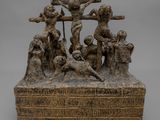une statue en bronze représentant Jésus sur la croix, entouré d'un groupe de personnes