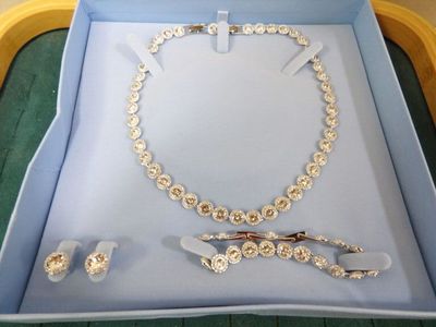 une boîte contenant un collier, des boucles d'oreilles et une paire de ciseaux