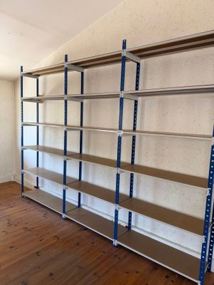 une pièce avec un parquet et des étagères métalliques