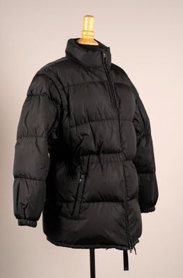 une veste noire posée sur un mannequin, sur fond blanc