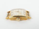 a close up of a watch on a white surface with a white background