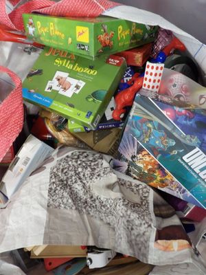 un sac rempli de jouets et de jeux posé par terre