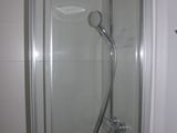 a shower with a glass door in a small bathroom
