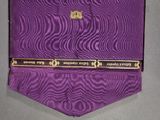 a purple tie with a gold emblem on it