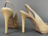 pair of women ' s nude colored high heeled shoes on a gray surface