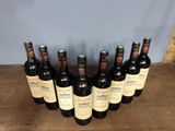 six bottles of wine are lined up in a row on a wooden table