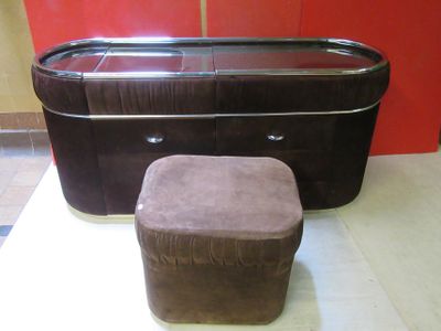 un pouf marron posé à côté d'une commode dans une pièce