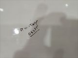 a picture of a white toilet with a black sticker on it