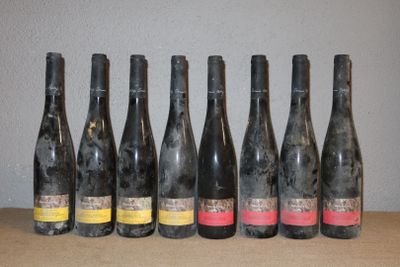 six bouteilles de vin alignées sur une table, avec un mur en arrière-plan
