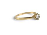 a close up of a gold ring with a diamond on it