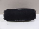 a black speaker sitting on top of a table next to a wall