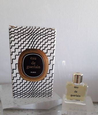 des flacons de parfum posés sur un plan de travail, à côté d'une boîte