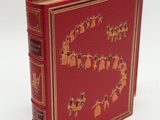 an old book with a red cover with a gold design