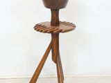 a wooden stand with a wooden bowl on top of it