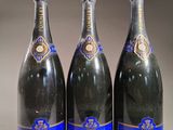trois bouteilles de vin sont alignées sur une table