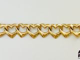 un gros plan sur un bracelet en or orné de cœurs