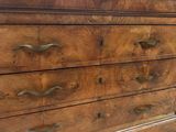 a wooden dresser with a marble top in a room