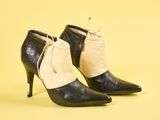 bottes noires et blanches à talons hauts, avec un cordon de serrage sur le côté