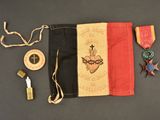 un drapeau orné d'une croix, une médaille et d'autres objets posés sur une table
