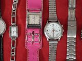 a lot of watches that are sitting on a red surface