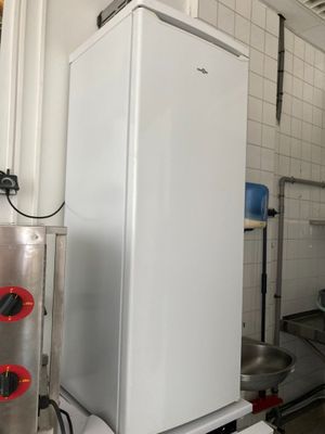 un réfrigérateur blanc au milieu d'une cuisine remplie d'appareils électroménagers