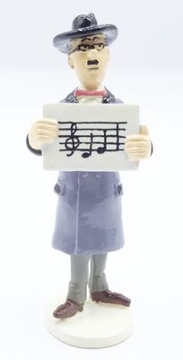 a figurine of a man holding a sign with music notes