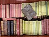 de nombreux livres anciens dans une caisse en bois posée sur l'étagère