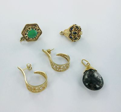 three pairs of gold earrings and a ring with a green stone