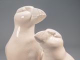 two ceramic cats sitting next to each other on a table
