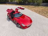 the red sports car is parked on a paved area with its open doors open