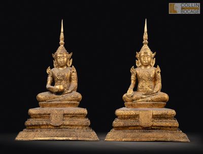 une paire de statues de Bouddha en or sur fond noir