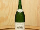 une bouteille de vin posée sur un tonneau en bois