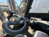 le volant d'un tracteur garé devant un bâtiment