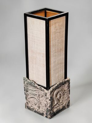un grand vase avec un socle en bois, dans lequel se trouve un livre