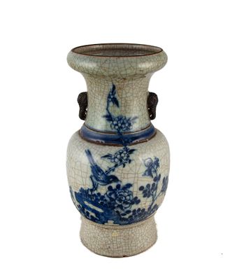 un vase bleu et blanc posé sur une surface blanche