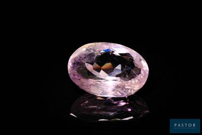 gros plan d'un diamant rose sur une surface noire