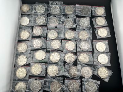 une boîte remplie de pièces d'argent qui se trouvent dans une boîte